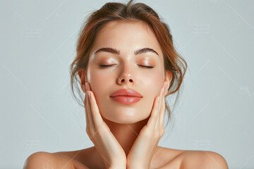Close up portrait of a beautiful woman with closed eyes touching her neck and holding her hand on it. She has healthy skin in the style of a beauty studio setting over a grey background.