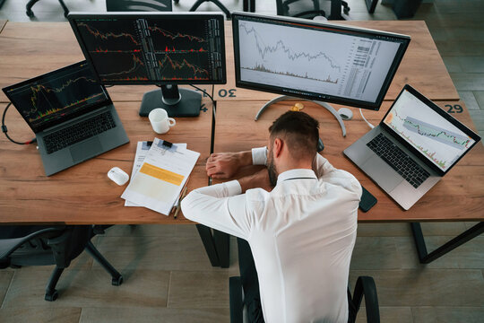 Tired, sleeping on the table. Businessman is sitting by computer and working in the office