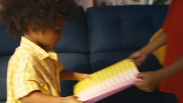 Two African American boys fighting over a toy at home, siblings rivalry