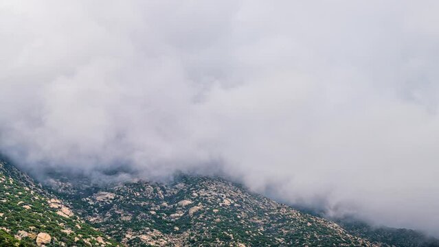 Fog clouds moving timelapse time lapse over rocky mountains cliff in Magganitis, Ikaria island of Greece at north Aegean Mediterranean sea