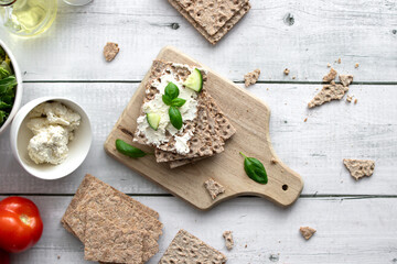 healthy crispy wheat bread with cheese, cucumber on a wooden background. breakfast