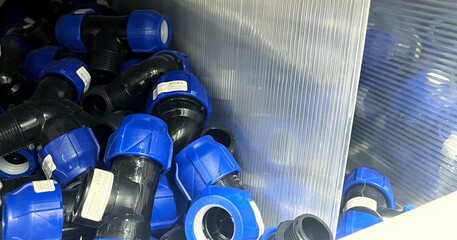 Blue plastic plumbing pipe adapters in a store. International Repair Day. World Plumber Day