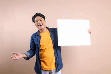 Asian man wear casual clothes holding white blank board for mockup or ads with happy expression