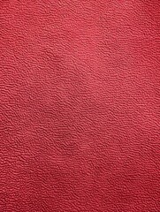 Fototapeta premium A close examination of a brilliantly crimson-colored leather surface, showcasing its intricately detailed, almost hypnotic texture. Velvety alcantara texture