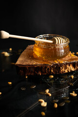 Fresh honey in a glass jar on a black background. Deliciously