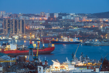 Vladivostok city, Primorsky Krai, Russia. View of ships in the Golden Horn Bay. Residential buildings in the distance. Evening twilight. Beautiful cityscape. Travel to the Russian Far East.