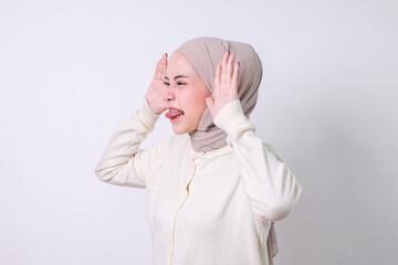Side view of young moslem woman making a silly face with her tongue sticking out.