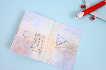 Republic of Indonesia passport pages with various stamps and toy plane over blue background