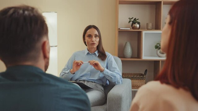Focused psychologist gestures calmly, mediating couples dialogue with skill and empathy, helping them navigate through their conversation.