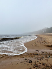 Waves on the foggy sea beach