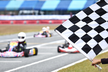 Track officer waving the finish flag for go kart racing at the finish line