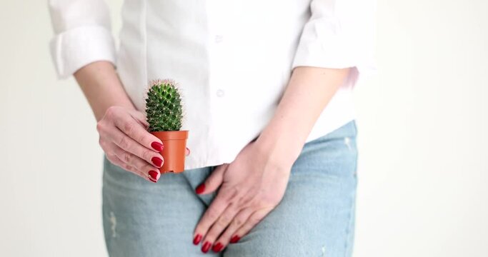 Woman holding cactus and covering genitals with disease with hand closeup 4k movie slow motion. Sexually transmitted infections symptoms and treatment concept