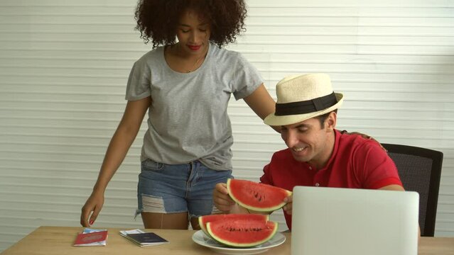 Interacial african and hispanic couple workation work from anywhere summer time watermelon and computer 4k