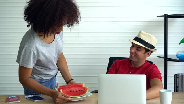 Interacial african and hispanic couple workation work from anywhere summer time watermelon and computer