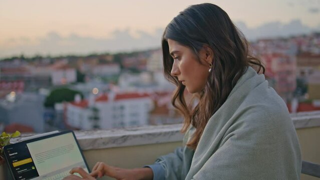 Focused girl writing diploma laptop at sunset city panorama closeup. Lady typing