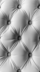 Striking black and white image highlighting the intricate, tufted texture of a plush leather surface, creating a visually captivating abstract pattern.