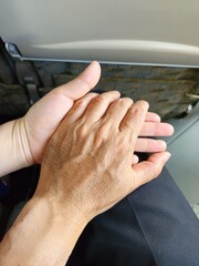 Couple holding hands in the airplane.