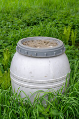 Environmental pollution-  a plastic barrel abandoned in a meadow