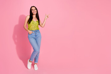 Photo of adorable pretty nice girl wear trendy clothes introduce empty space isolated on pink color background