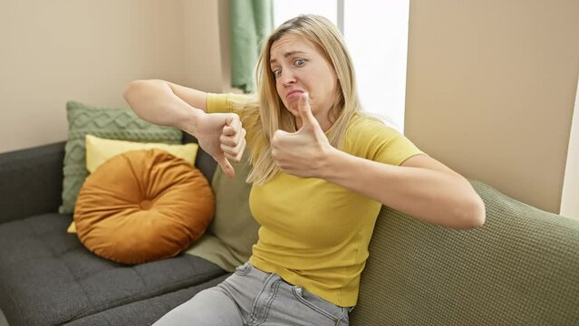 Crazy thumb war conflict at home! young blonde woman in t-shirt showing thumbs up and down, expressing agreement and discord. an intriguing portrait of indoor decision-making.