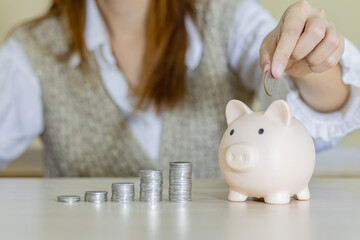 woman hand putting money coin into piggy for saving money wealth and financial concept, Stack of coins arranged together