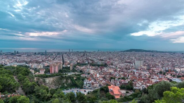 Barcelona Unveiled: Night to Day Timelapse Panorama of Spain's Catalonian Jewel. From the Bunkers of Carmel, Aerial Top View Captures the City Lights Fading as Dawn Paints the Sky in Gentle Hues