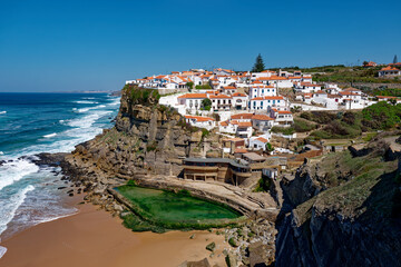 Fototapeta na wymiar Azenhas do Mar, Portugal. Natural pool in the ocean, next to the cliff and a seaside village during sunset. Best destinations in the world. Most visited places. Holidays. Scenic and exotic.