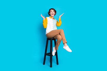 Photo of positive cheerful girl sit chair impressed isolated blue color background