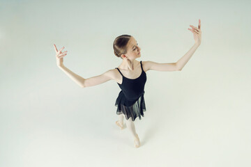 young teen ballerina posing in motion dance elements top view