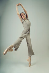 young teenage ballerina in a photo studio poses in a fashionable coverall showing elements of dance