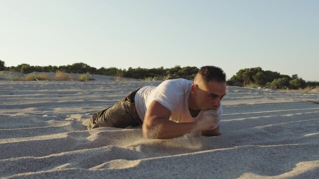 Military man performs tests of strength and endurance on the beach