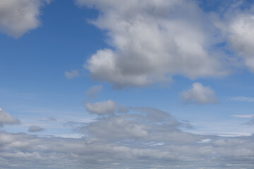 Expansive blue sky punctuated by soft, puffy clouds, creating an ideal backdrop for creative...