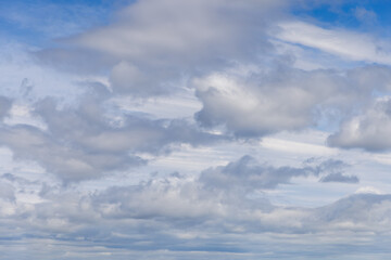 A dynamic sky panorama unfolds with an array of cumulus clouds, ranging from soft, delicate forms...