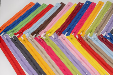 Multicolored Plastic Zippers or Zip Fasteners with sliders pattern for handmade sewing tailoring used for binding fabric or textile
