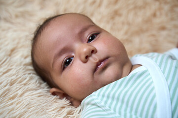 Portrait of a newborn baby lying on a fluffy blanket