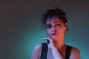 Obraz premium Portrait of beautiful woman on dark background with neon lights