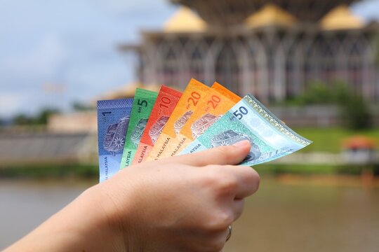 Hand with Malaysian ringgit paper money