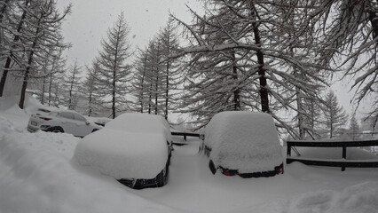 Captivating winter scene in Breuil Cervinia with heavy snowfall blanketing apartments, trees, and cars near Cervino Ski paradise, captured with GoPro 11.