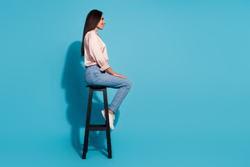 Full length photo of cute positive woman wear silky blouse sitting chair looking empty space...