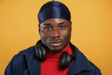 Serious facial expression. Handsome black man is in the studio against yellow background