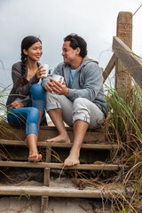 Asian Man Woman Romantic Couple on Beach Steps Drinking Coffee or Tea