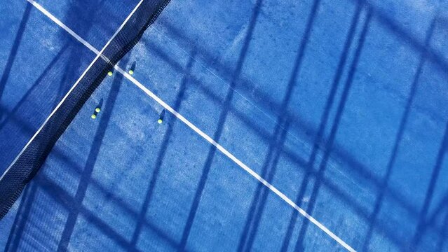 downward drone video footage on a blue paddle tennis court, sports courts concept