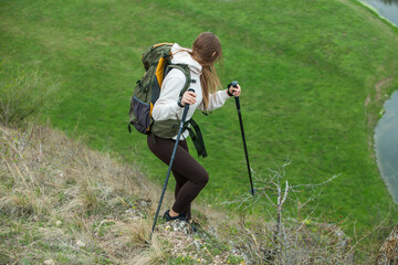 Young woman with backpack hiking in the mountains. Hiking concept. Trekking cliffs. Travel, traveler.