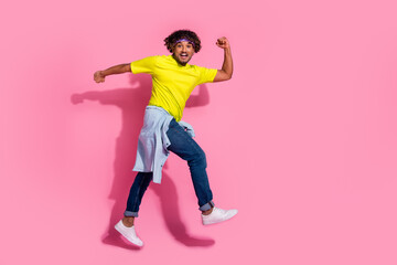 Fototapeta na wymiar Photo of young nice positive man wear trendy yellow clothes move walk empty space isolated on pink color background