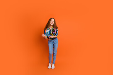 Photo of cheerful positive lovely girl wear stylish print clothes dance chill vibe isolated on vibrant orange color background