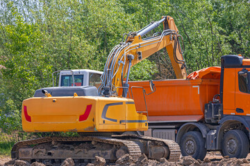 Excavator Loading Dirt in Tipper Truck at Construction Site