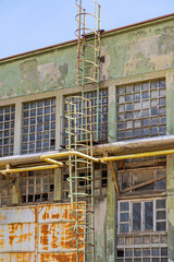 Vertical Ladders With Safety Cage at Rusty Old Abandon Factory Building Exterior