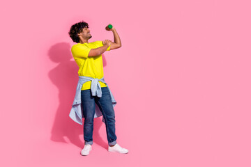 Photo of cheerful funny strong man wear stylish yellow clothes looking biceps triceps empty space isolated on pink color background