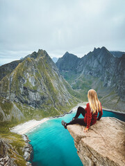 Woman on cliff edge above ocean traveling in Lofoten islands, girl enjoying aerial view in Norway summer active vacations solo traveler outdoor healthy lifestyle adventure trip - 777205306