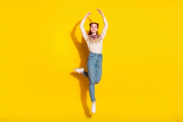 Küchenrückwand glas motiv Musikladen Photo portrait of pretty young woman jump dance ballet raise hands dressed stylish knitted warm outfit isolated on yellow color background